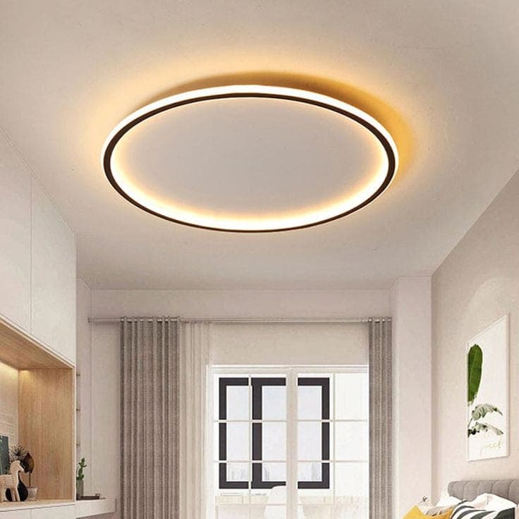 A flush circular LED ceiling light glowing warm above a room